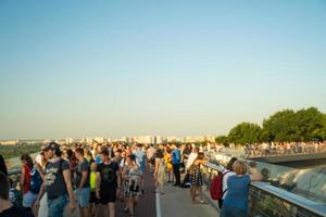 kiev, ucrania, 25.07.2021 - la gente camina y se relaja a lo largo del puente de peatones y bicicletas sobre el descenso de vladimirsky en kiev ucrania el fin de semana. al aire libre. foto