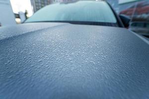 Raindrops on the hood of the car. Close-up. photo