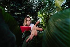 Young agricultural engineer examines leaves in greenhouse photo