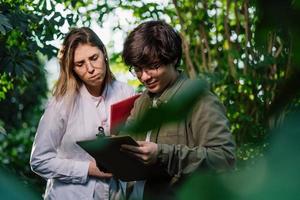 Young agricultural engineers working in greenhouse photo