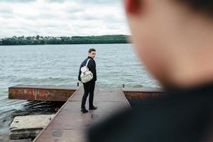 two young guys standing on a pier photo