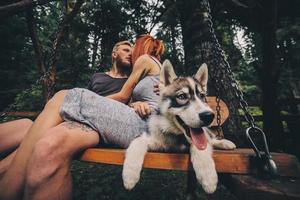 hermosa pareja junto con un perro en un columpio foto