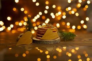 Two golden hearts lie on a wooden table with bokeh lights on the background photo