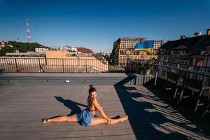 Young woman practicing yoga on the roof of a building photo