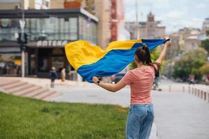 Young woman with national flag of Ukraine on the street photo