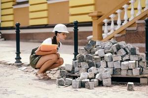 mujer ingeniera civil cuenta materiales de construcción en un sitio de construcción. foto