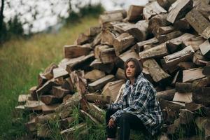 mujer en el bosque cerca del poste de madera cortada foto