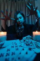 Woman fortune-teller guesses fate of night at table with candles photo