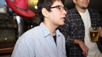 Guy with a beer in a bar with friends on a Saturday night photo