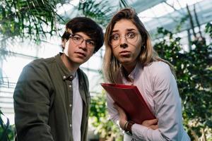 Young agricultural engineers working in big greenhouse photo