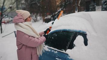 Woman removing snow from car photo