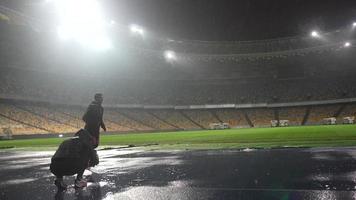 People go in for sports at night stadium in rainy weather photo