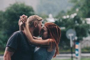 beautiful couple kissing in the rain photo