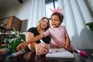 Mother and child daughter draws creatively at the table photo