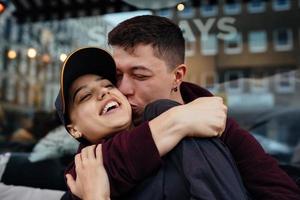 Guy and a girl are hugging at a table in a outdoor cafe. photo