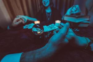 la gente se da la mano de la noche en la mesa con velas foto