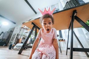 Little girl sitting on the floor grimacing at the camera photo