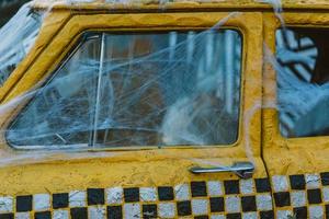 Old retro yellow taxi decorated with cobwebs photo