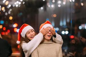 Portrait of happy cute young friends hugging each other at caffe. photo