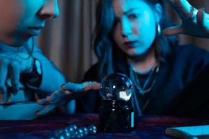 Woman and woman fortune teller with crystal ball photo