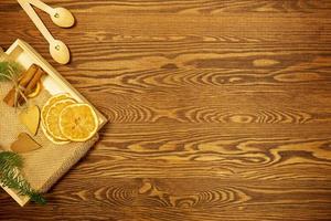 Dried oranges, a bunch of cinnamon and golden hearts on a wooden table photo