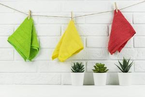 Fresh microfibre rags hanging on the string in the kitchen after cleaning service photo