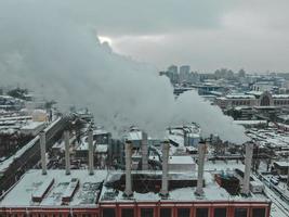 Large central boiler room with giant pipes of which there is dangerous smoke in winter during frost in a big city photo