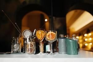 Four glass cups on the bar counter with serving accessories. photo