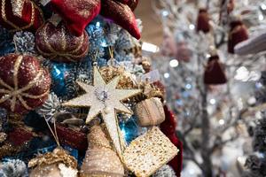 Different object toy gifts hanging on a decorated Christmas tree. photo