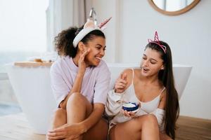 Two girls in the bath playing with face cream photo