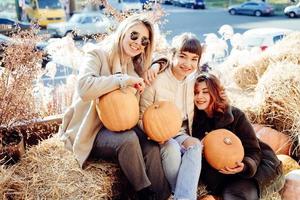 Girls holds pumpkins in hands on the background of the street. photo