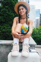 Beautiful young woman holds a small globe in her hands. photo