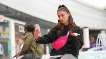 Woman using smartphone indoor. Texting and communicating in mall photo