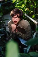 Male scientist hiding in the thicket. Nature protection and wildlife preservation concept. photo