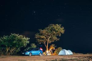 Group of five travellers rest on sea shore on evening sky background. photo