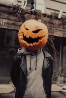 Guy with a  pumpkin head poses for the camera photo
