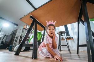 Little girl sitting on the floor grimacing at the camera photo