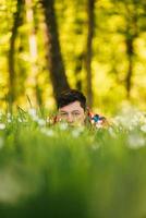 Young man hiding in the green grass photo