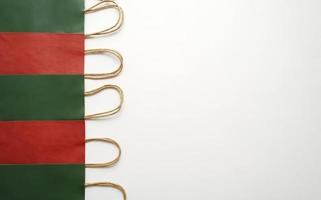 A row of colourful paper shopping bags lying on a white background photo