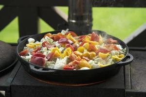 A stew made of red peppers, potatoes, beef, cabbage and other vegetables in a cast-iron cauldron photo