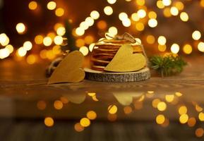 Two golden hearts lie on a wooden table with bokeh lights on the background photo