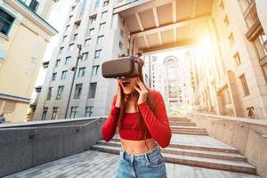 Woman in a virtual reality helmet walks down the street photo