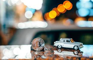 Silver bitcoin and Moskvich 401 on the table, glowing background photo