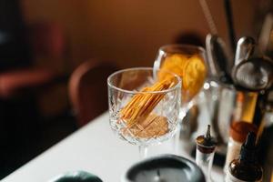 Four glass cups on the bar counter with serving accessories. photo