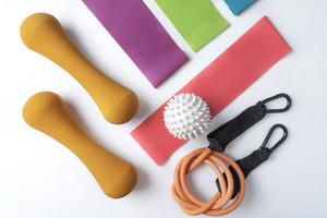 Different colourful equipment for fitnes and sport exercises balls, bands and expanders lying on a white background photo