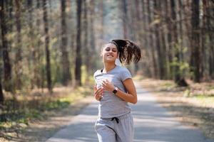 bella joven corriendo en un parque verde en un día soleado de verano foto