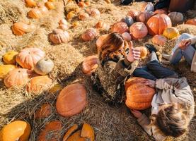 Young girls lie on haystacks among pumpkins. photo