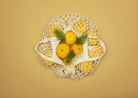 A white string bag full of tangerines photo