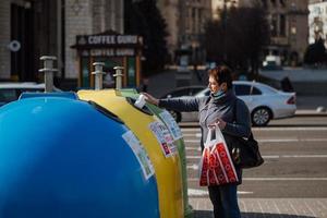 Kiev, Ukraine, March 28, 2020, Woman sorts trash at almost empty street, quarantine time at Ukraine, photo