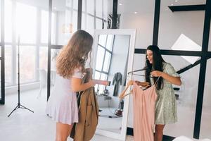 Two women choose and try on clothes at home photo